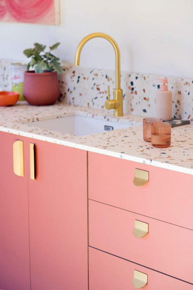 На фото: прямая кухня-гостиная в стиле модернизм с плоскими фасадами, розовыми фасадами, столешницей терраццо и разноцветной столешницей с