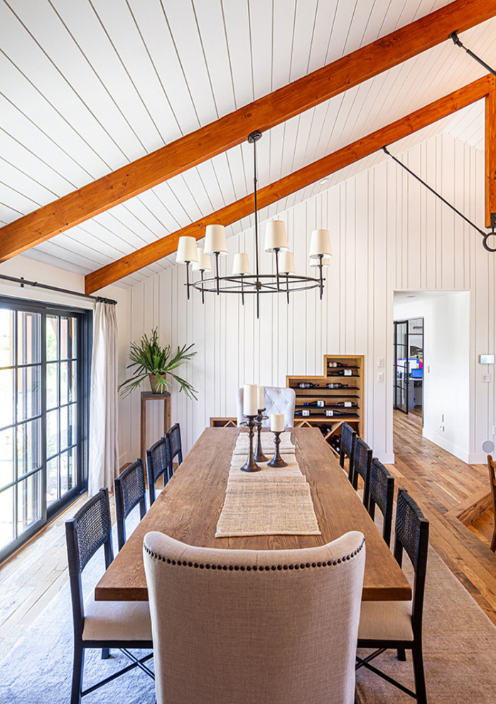 Coburg Farmhouse Remodel - Huge medium tone wood floor, brown floor, exposed beam and wall paneling kitchen/dining room combo photo with white walls