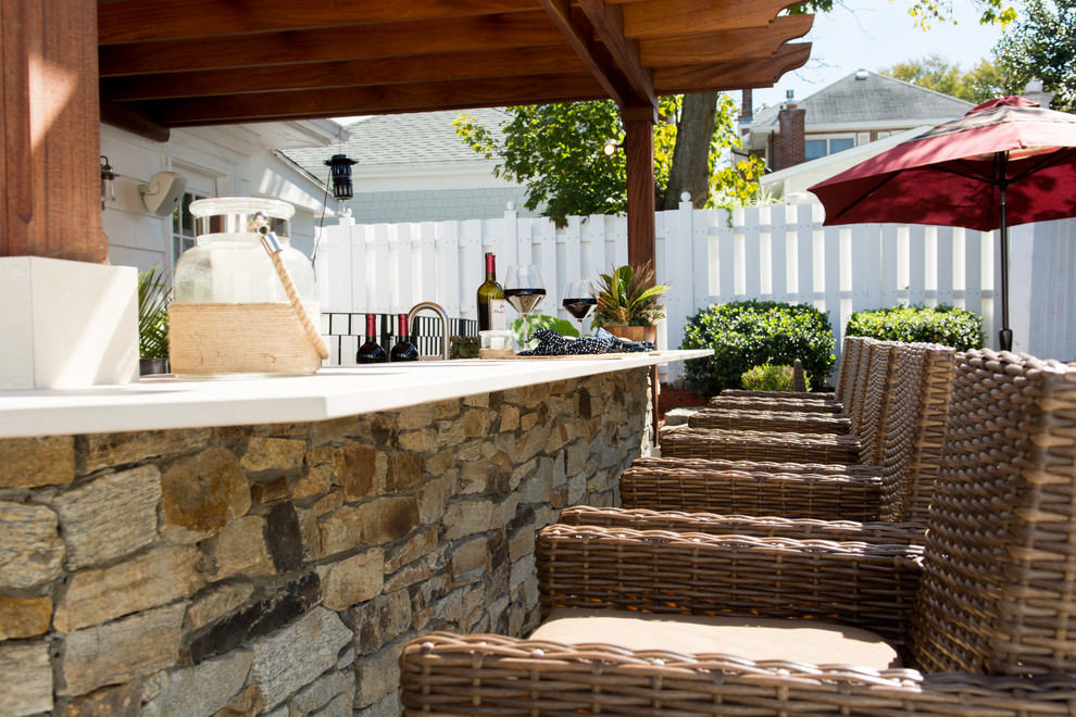 Photo of an expansive backyard patio in Providence with an outdoor kitchen, a pergola and stamped concrete.