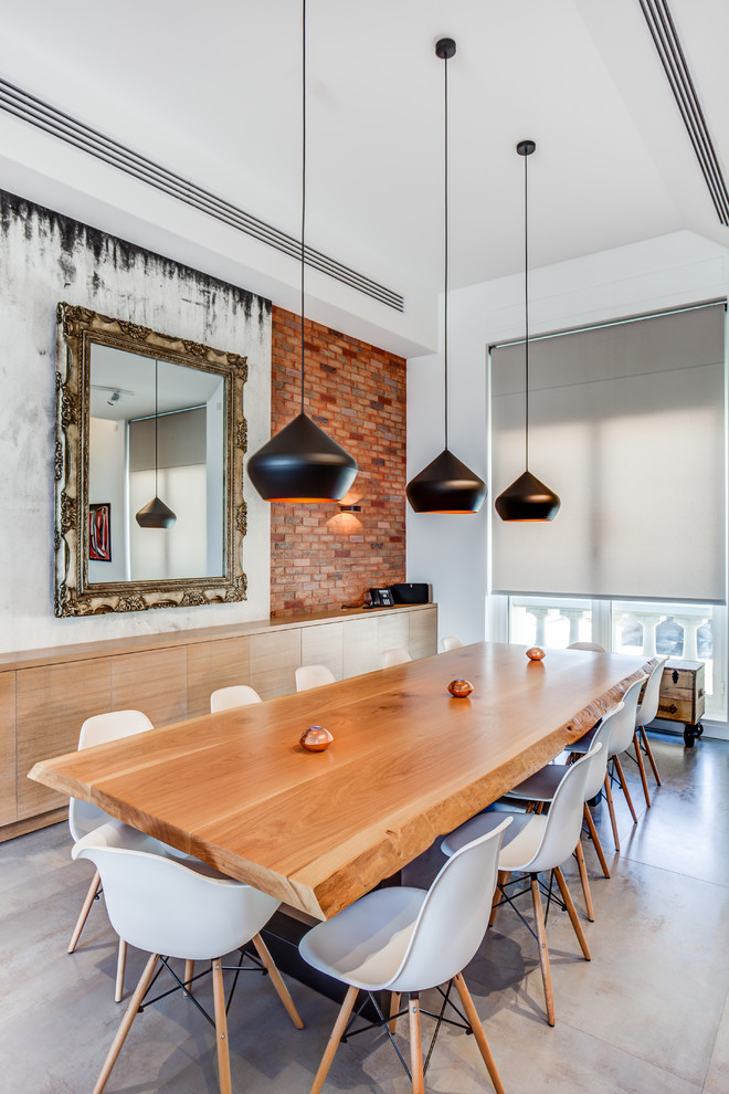 Photo of an industrial separate dining room in Madrid with white walls and grey floor.