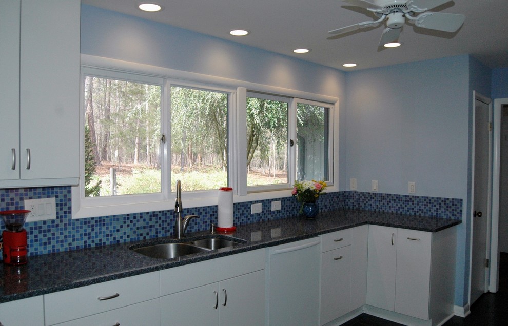 Design ideas for a kitchen in Raleigh with an undermount sink, flat-panel cabinets, white cabinets, blue splashback, glass tile splashback and stainless steel appliances.