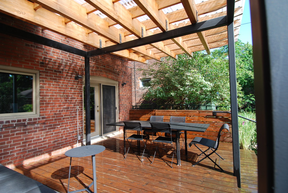 This is an example of a modern backyard patio in Toronto with decking and a pergola.