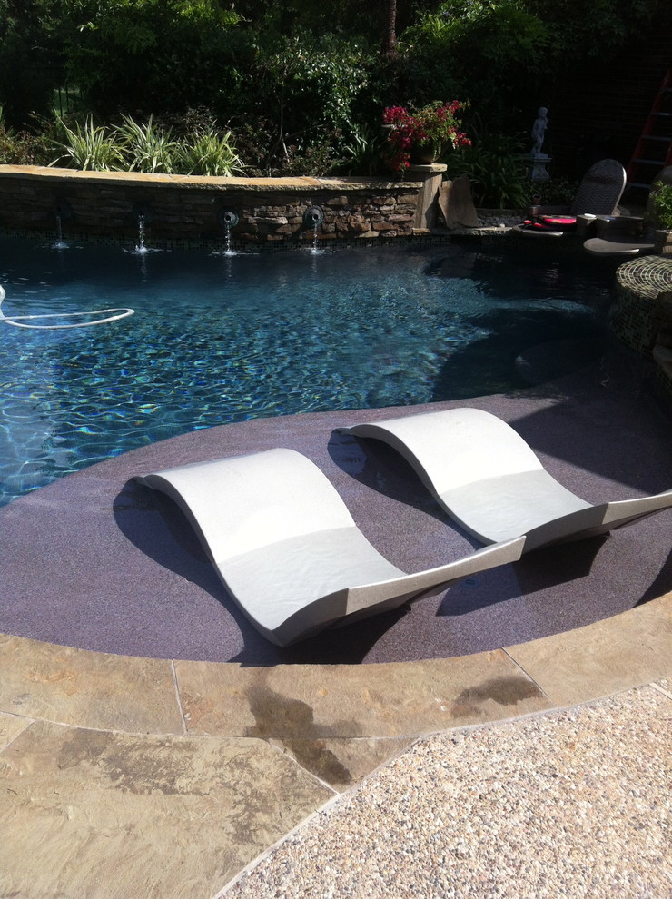 This is an example of a contemporary backyard custom-shaped lap pool in Houston with natural stone pavers.