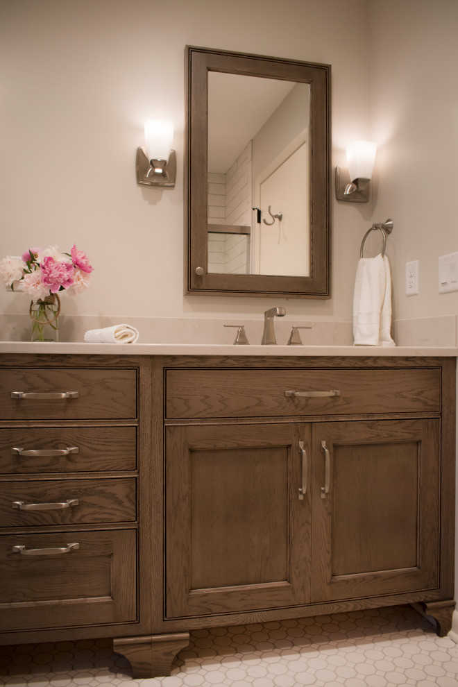 Example of a mid-sized transitional master mosaic tile floor and beige floor bathroom design with furniture-like cabinets, medium tone wood cabinets, beige walls, an undermount sink, quartz countertops and beige countertops