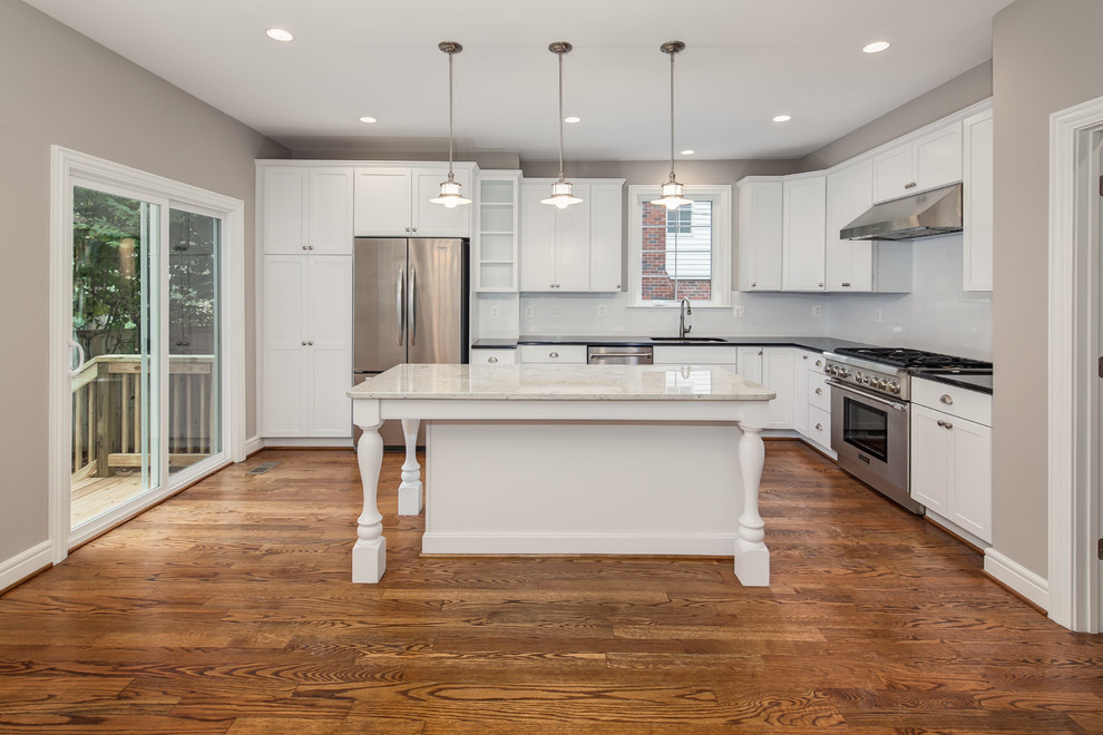 Inspiration for a large transitional l-shaped open plan kitchen in DC Metro with an undermount sink, shaker cabinets, white cabinets, white splashback, stainless steel appliances, medium hardwood floors, with island and subway tile splashback.