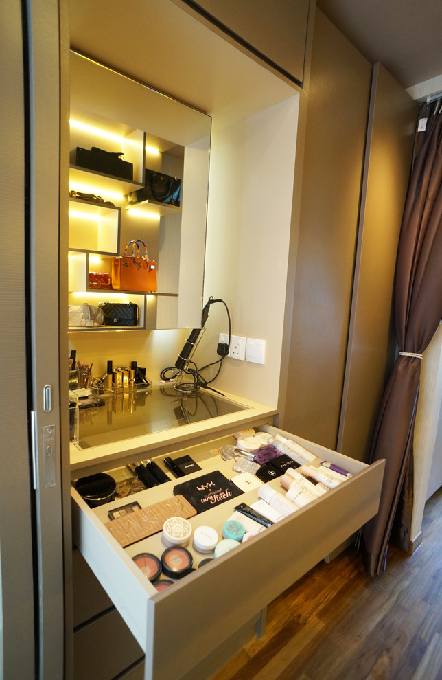 Small modern storage and wardrobe in Singapore with beige cabinets and dark hardwood floors.