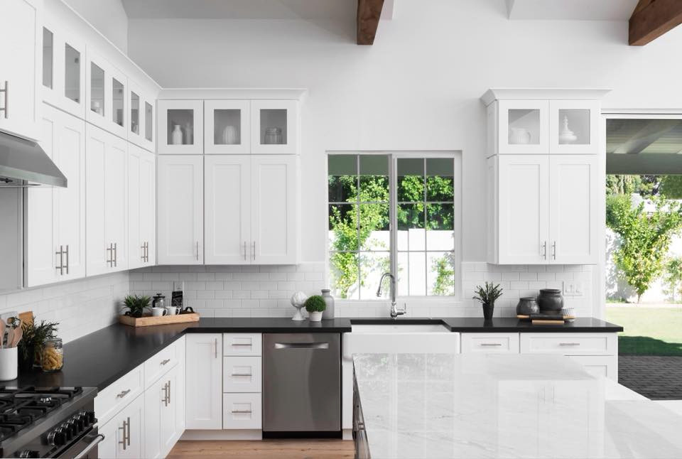 Inspiration for a country kitchen in Phoenix with a farmhouse sink, shaker cabinets, white cabinets, marble benchtops, white splashback, stainless steel appliances, light hardwood floors and vaulted.