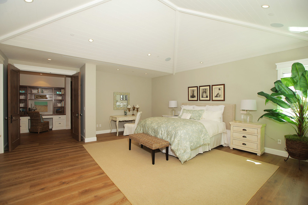 Photo of a large country master bedroom in Los Angeles with beige walls, medium hardwood floors and a wood fireplace surround.
