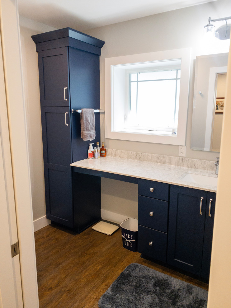 Mid-sized transitional l-shaped medium tone wood floor and brown floor eat-in kitchen photo with an undermount sink, flat-panel cabinets, light wood cabinets, quartz countertops, yellow backsplash, subway tile backsplash, stainless steel appliances, an island and white countertops