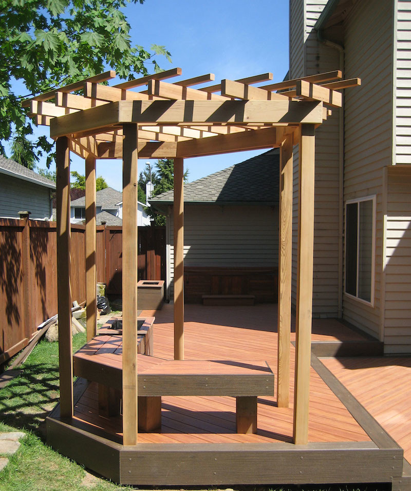 Example of a mid-sized backyard deck design in Seattle with a pergola