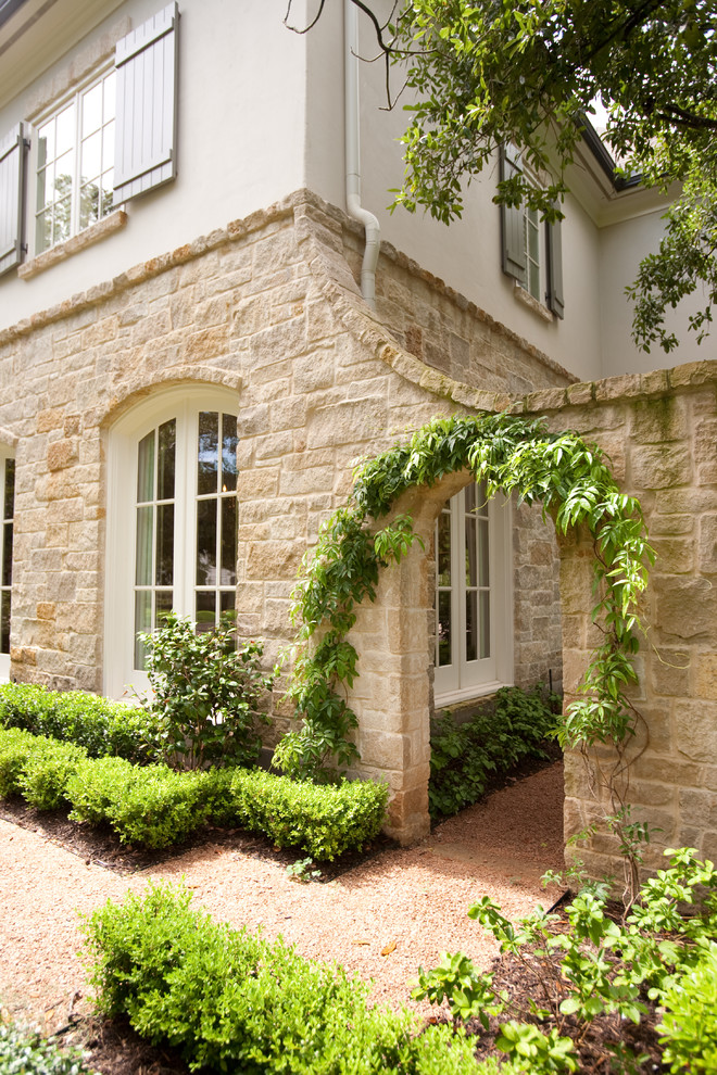 Large traditional two-storey beige exterior in Houston with stone veneer.