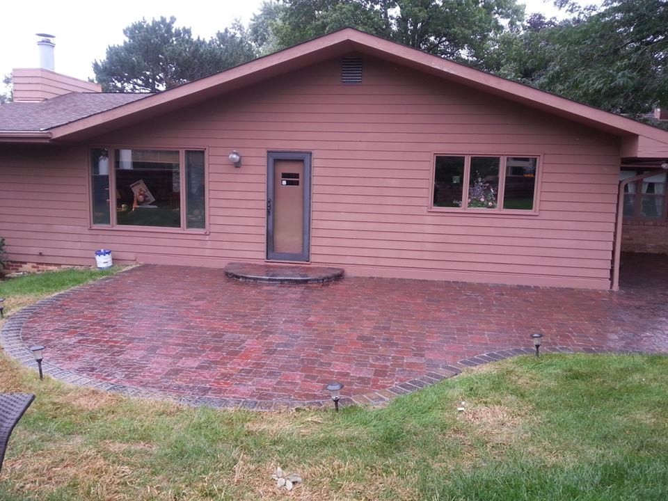 Photo of a mid-sized modern side yard patio in Omaha with brick pavers.