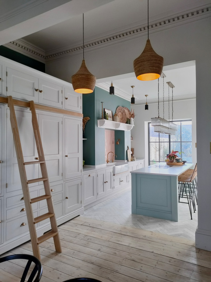 Inspiration for a mid-sized arts and crafts single-wall eat-in kitchen in Other with a farmhouse sink, shaker cabinets, white cabinets, granite benchtops, pink splashback, porcelain splashback, black appliances, marble floors, with island, white floor and pink benchtop.