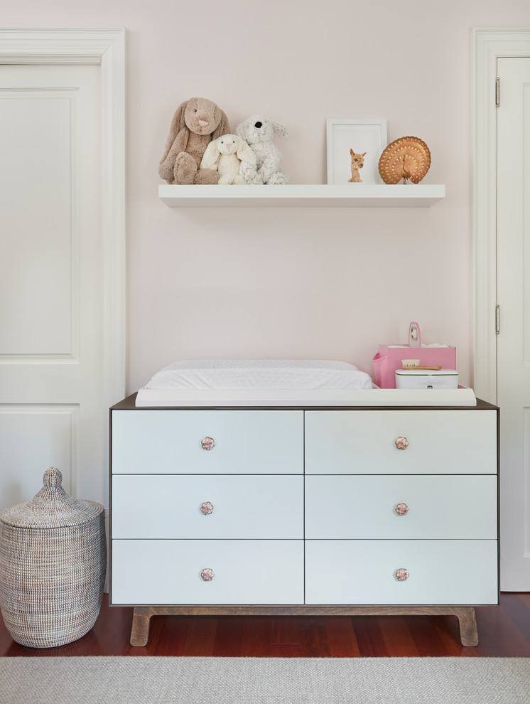 Mid-sized transitional nursery in Toronto with pink walls, medium hardwood floors and brown floor for girls.
