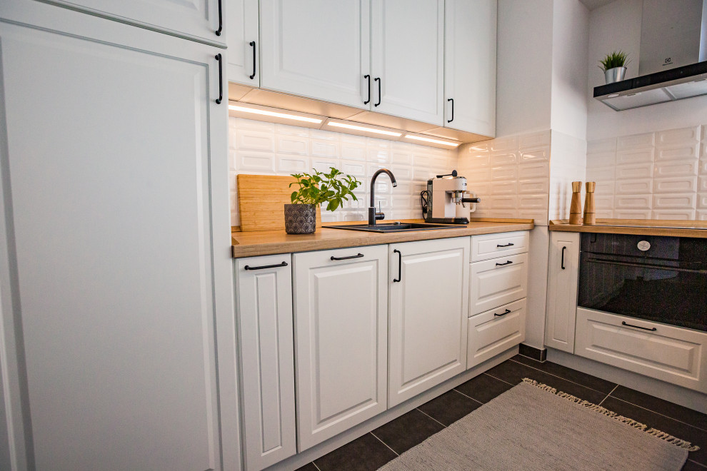 Aménagement d'une petite cuisine scandinave avec des portes de placard blanches, un plan de travail en bois et un plan de travail marron.