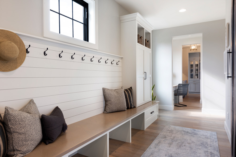 Photo of a transitional mudroom in Minneapolis with grey walls and light hardwood floors.