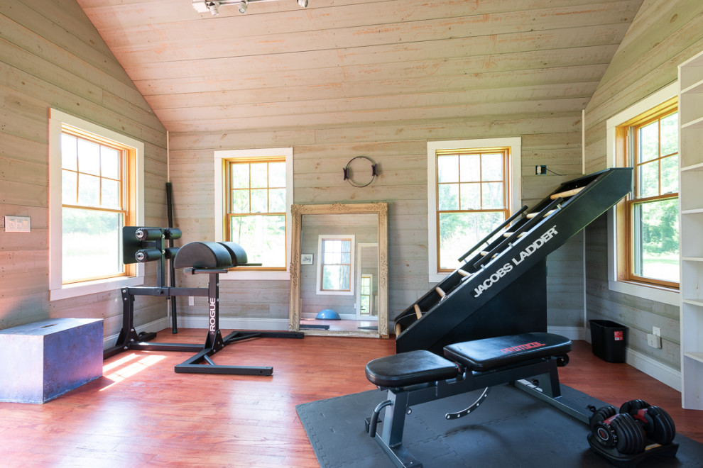 Inspiration for a mid-sized country home weight room in New York with medium hardwood floors and red floor.
