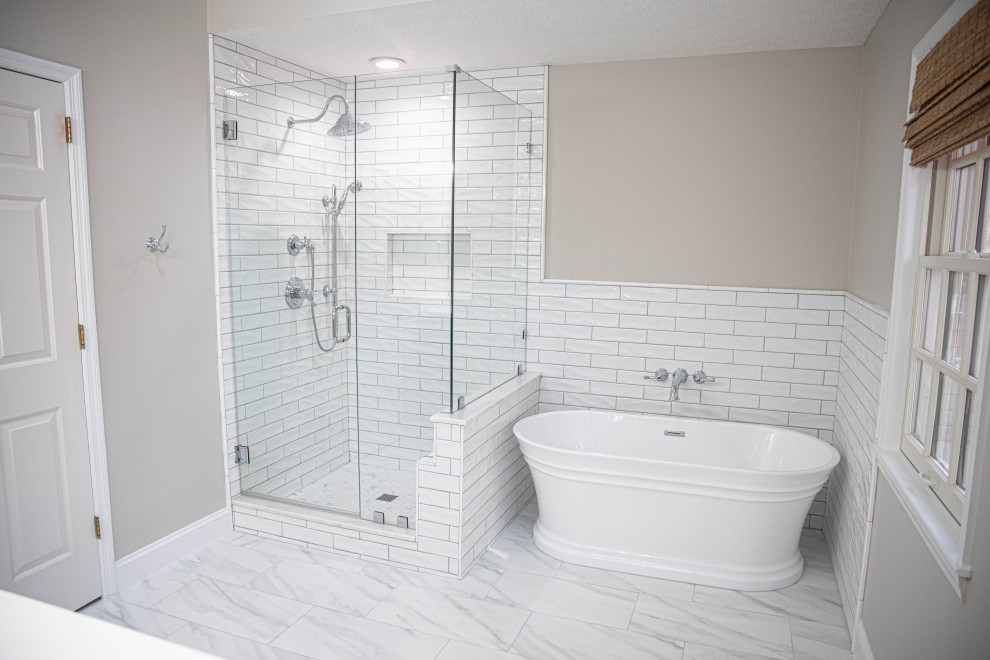 Klassisk inredning av ett mellanstort vit vitt en-suite badrum, med skåp i shakerstil, grå skåp, ett fristående badkar, en toalettstol med separat cisternkåpa, vit kakel, keramikplattor, grå väggar, klinkergolv i keramik, ett integrerad handfat, bänkskiva i kvarts, vitt golv och dusch med gångjärnsdörr
