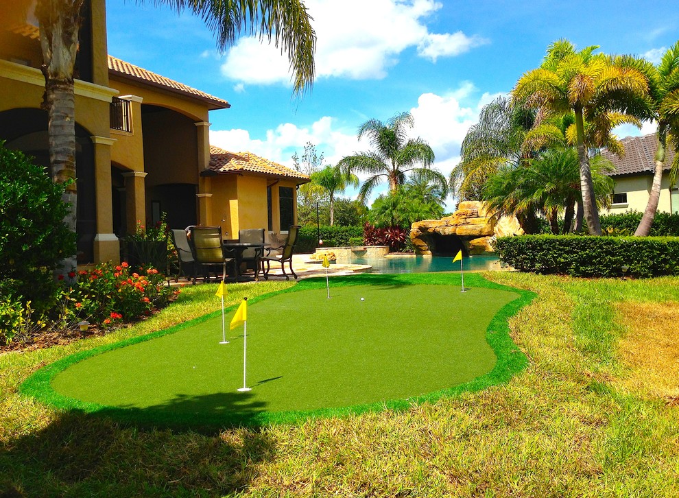 This is an example of a large traditional backyard partial sun outdoor sport court in Orlando with a water feature and mulch.