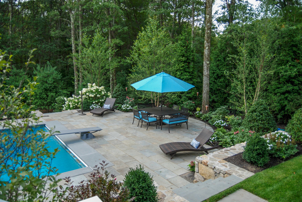 Inspiration for a large traditional full sun backyard stone landscaping in Boston.