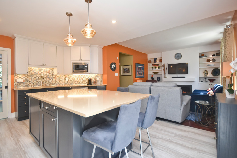 Mid-sized transitional l-shaped vinyl floor and beige floor kitchen photo in Ottawa with a double-bowl sink, shaker cabinets, white cabinets, quartzite countertops, multicolored backsplash, mosaic tile backsplash, stainless steel appliances, an island and beige countertops