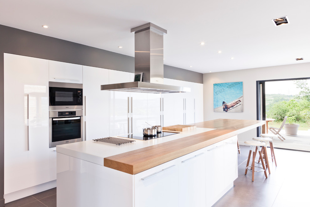 This is an example of a large contemporary single-wall eat-in kitchen in Lyon with flat-panel cabinets, white cabinets and with island.