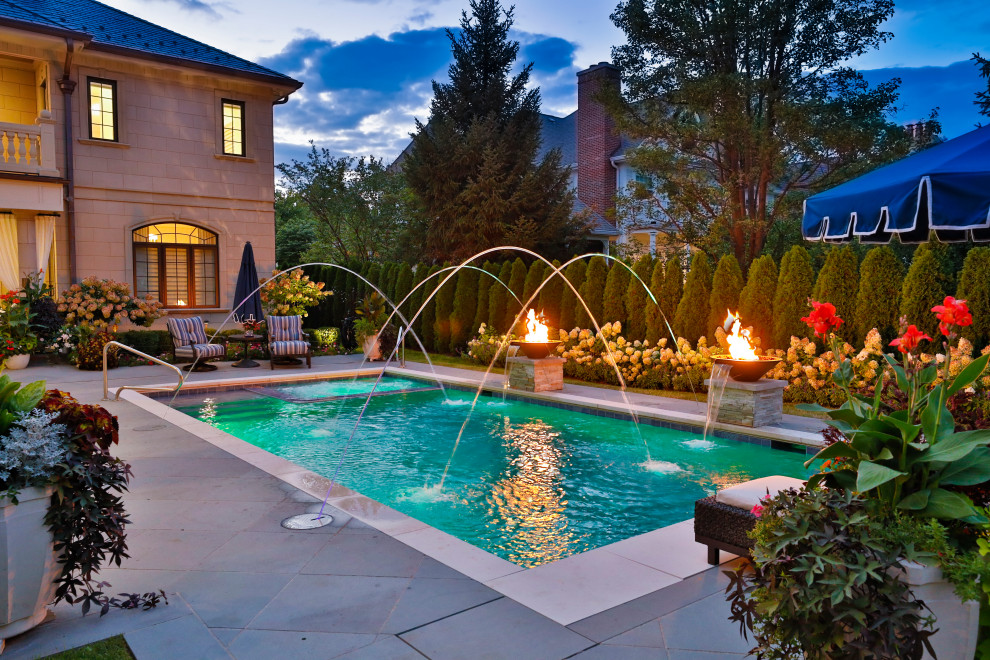 На фото: спортивный, прямоугольный бассейн среднего размера на заднем дворе в классическом стиле с перегородкой для приватности и покрытием из каменной брусчатки