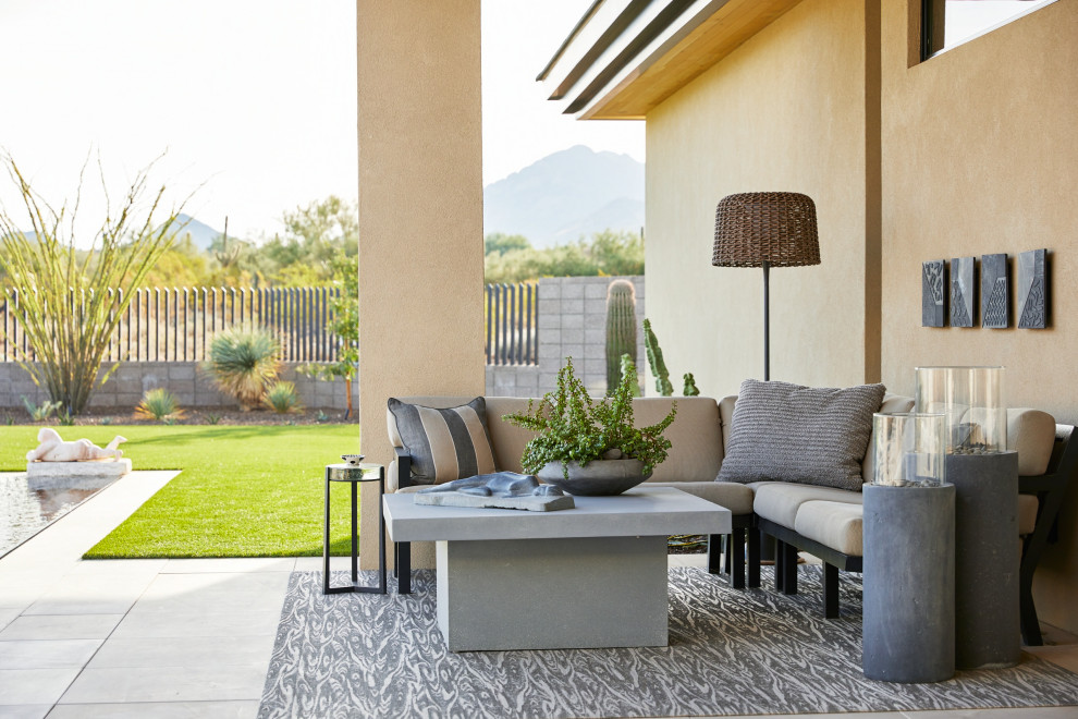 Expansive backyard patio in Phoenix with a fire feature, tile and a roof extension.