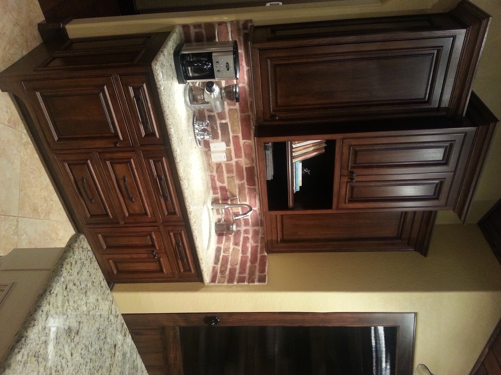 Inspiration for a large rustic u-shaped porcelain tile eat-in kitchen remodel with an undermount sink, raised-panel cabinets, dark wood cabinets, granite countertops, red backsplash, brick backsplash, stainless steel appliances and two islands