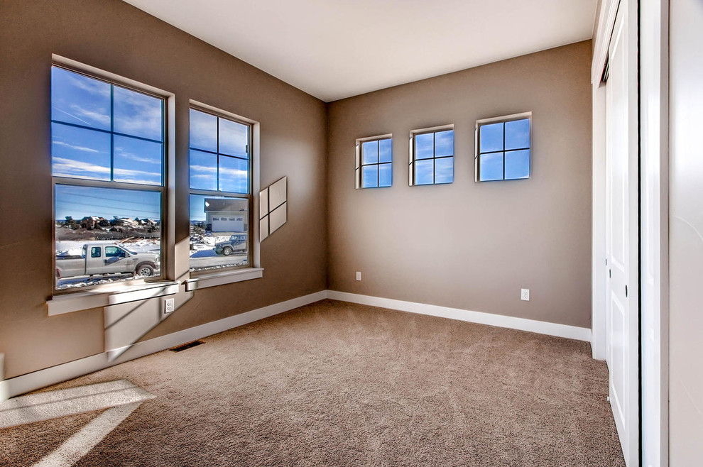 Contemporary guest bedroom in Denver with beige walls and carpet.