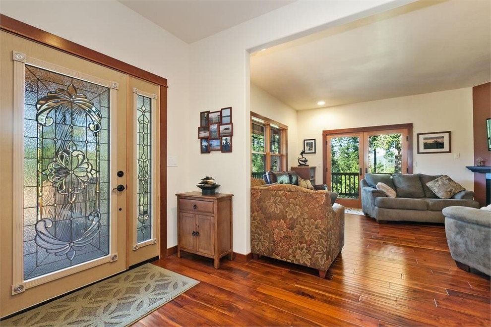 Foyer - large medium tone wood floor foyer idea in Seattle with white walls and a light wood front door
