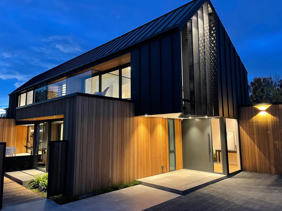 Große Moderne Haustür mit beiger Wandfarbe, hellem Holzboden, Einzeltür, schwarzer Haustür und Holzwänden in Christchurch