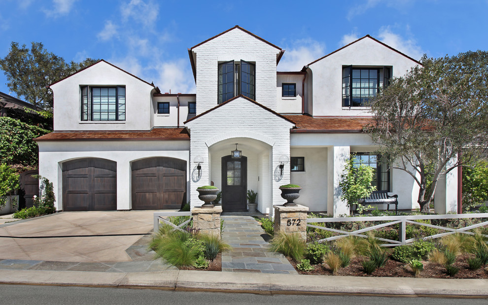 This is an example of a traditional two-storey white house exterior in Los Angeles with a gable roof.