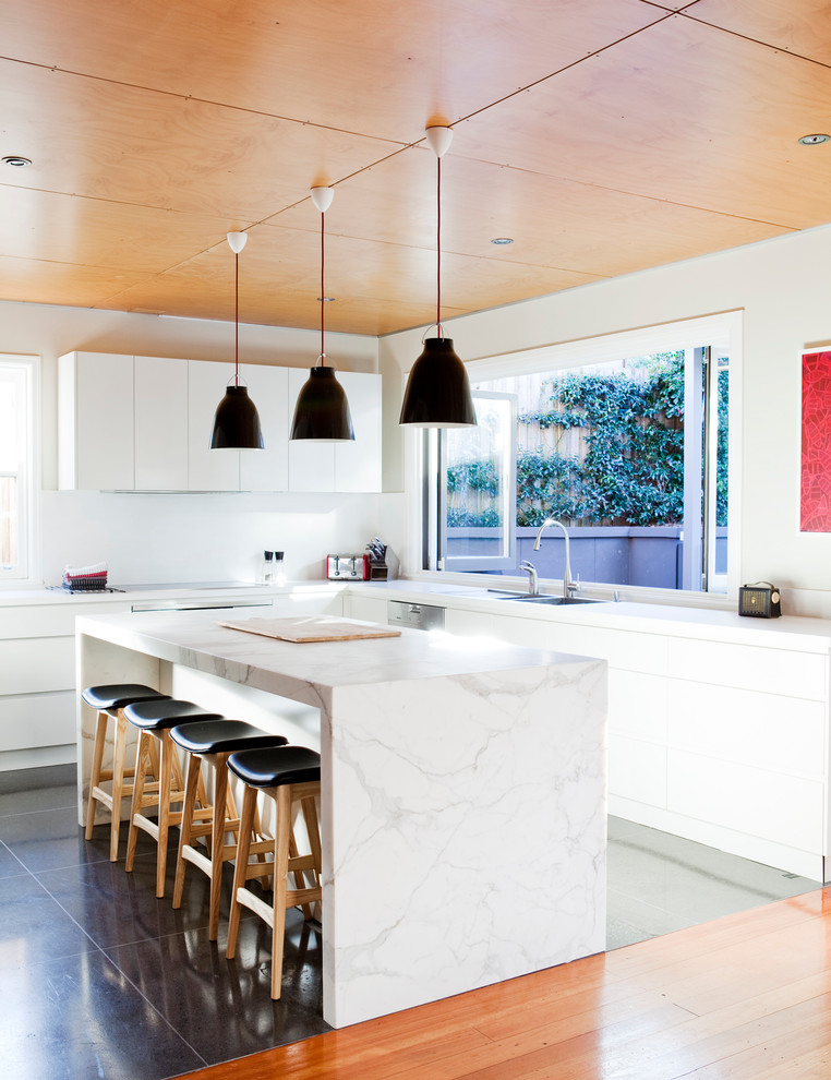 Inspiration for a mid-sized midcentury l-shaped eat-in kitchen in Sydney with an undermount sink, flat-panel cabinets, white cabinets, marble benchtops, white splashback, stainless steel appliances and with island.