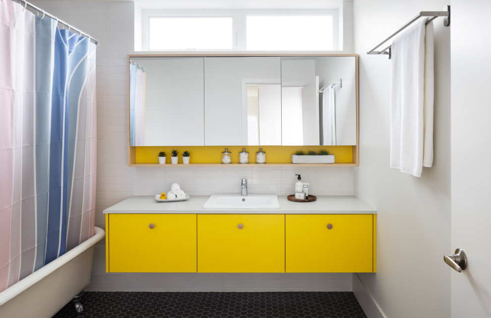 Photo of a mid-sized contemporary kids bathroom in Vancouver with flat-panel cabinets, yellow cabinets, a claw-foot tub, a shower/bathtub combo, white tile, subway tile, white walls, a drop-in sink, laminate benchtops, black floor, a shower curtain, white benchtops, a single vanity and a floating vanity.