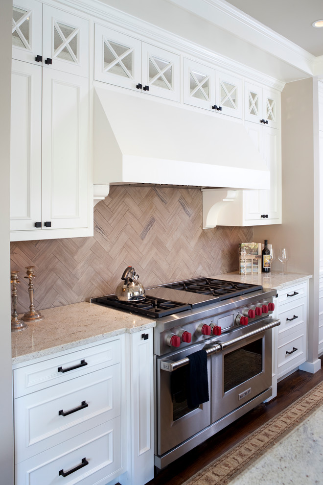 This is an example of a traditional l-shaped eat-in kitchen in DC Metro with a farmhouse sink, raised-panel cabinets, white cabinets, granite benchtops, grey splashback, stainless steel appliances and limestone splashback.