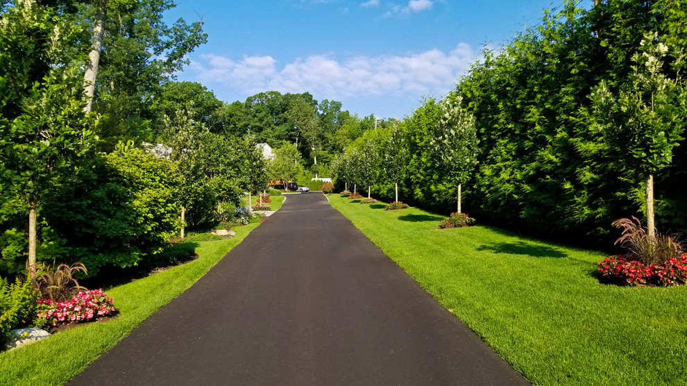 This is an example of a large traditional front yard full sun driveway in New York with a garden path and gravel.