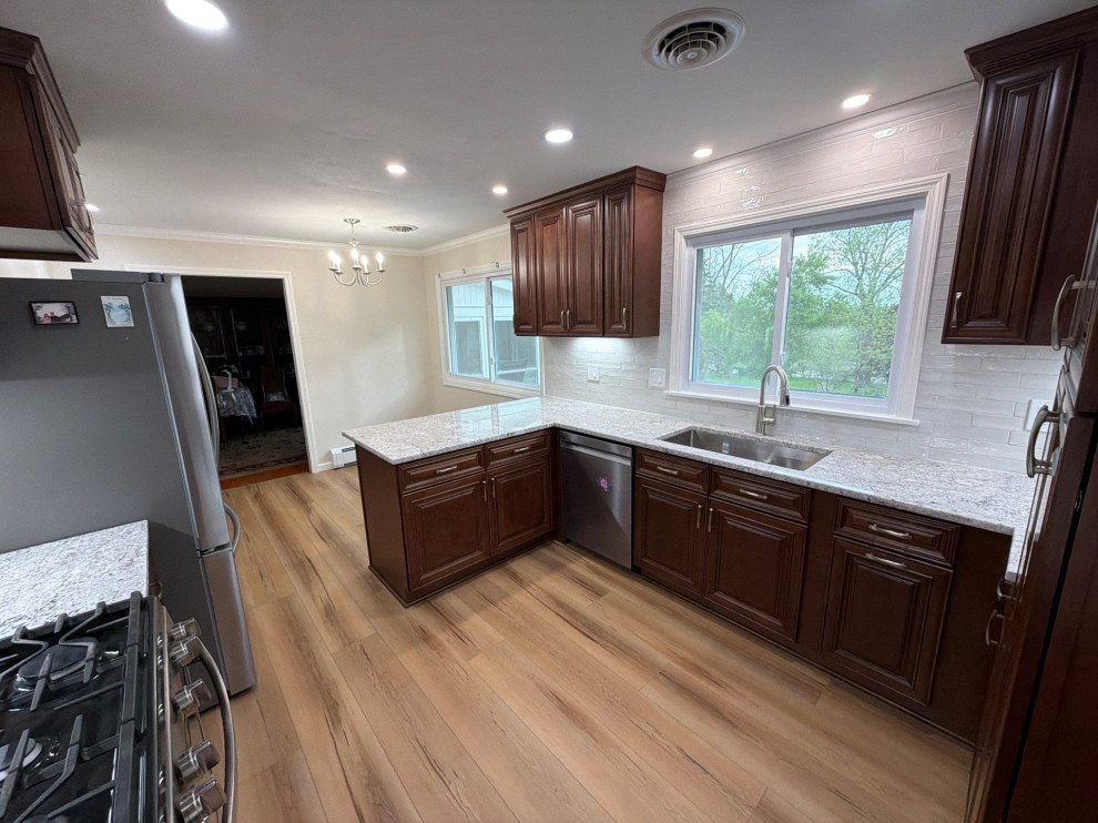 USCD cabinetry accompanied granite countertops, porcelain tile backsplash and Ca