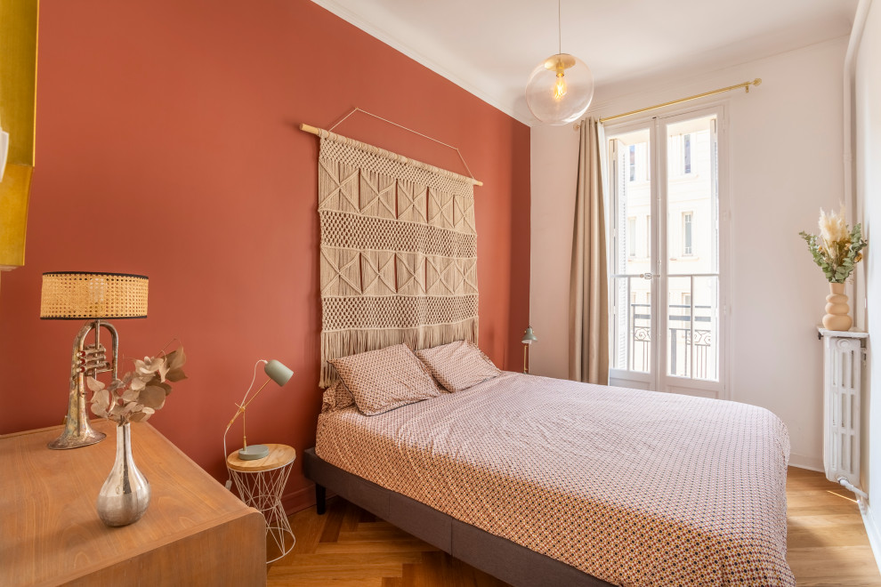 Diseño de dormitorio principal mediterráneo de tamaño medio sin chimenea con paredes rojas, suelo de madera clara y suelo beige