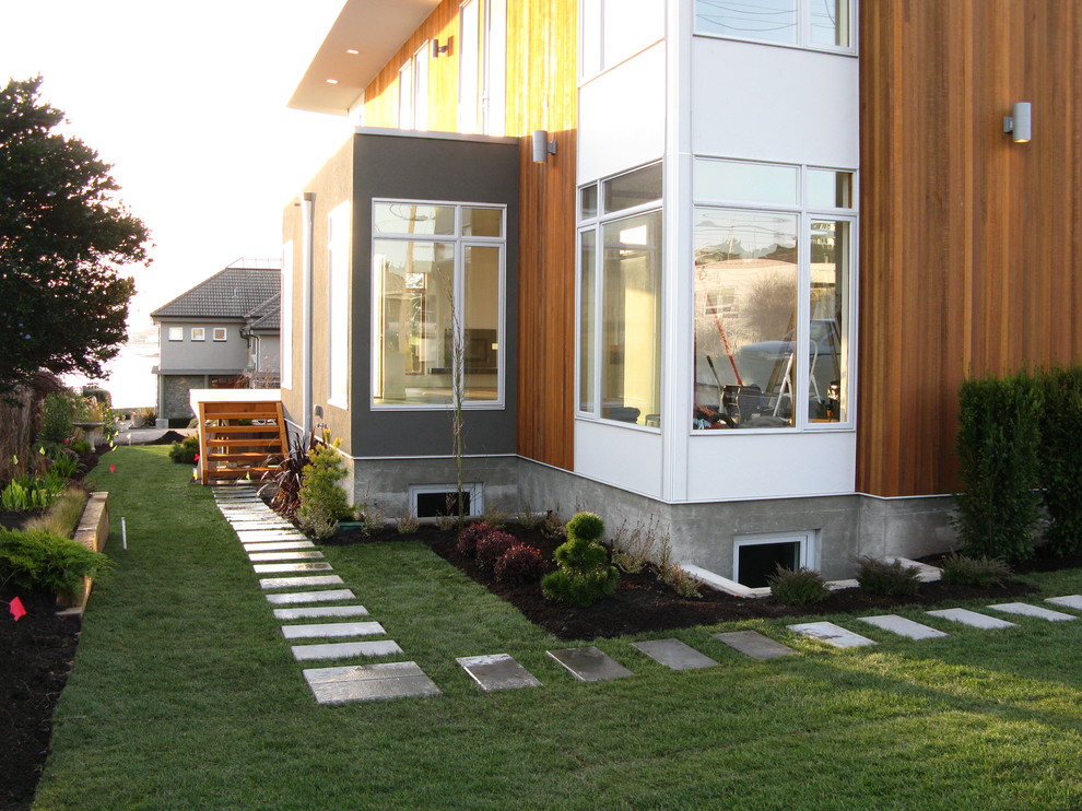 Small modern side yard full sun garden in Vancouver with concrete pavers for summer.