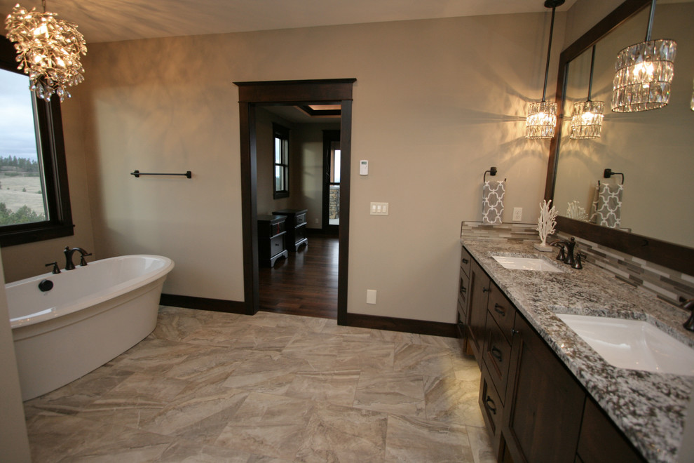 Large mountain style master beige tile and porcelain tile porcelain tile freestanding bathtub photo in Seattle with shaker cabinets, dark wood cabinets, a two-piece toilet, beige walls, an undermount sink and granite countertops