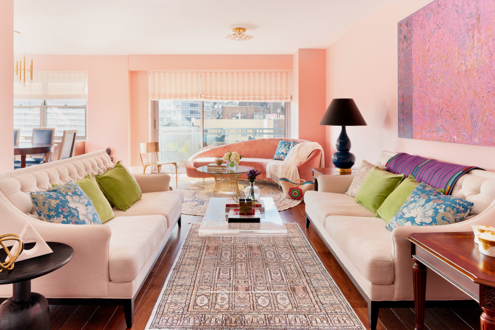 Aménagement d'un salon éclectique avec un mur rose, un sol en bois brun et un sol marron.