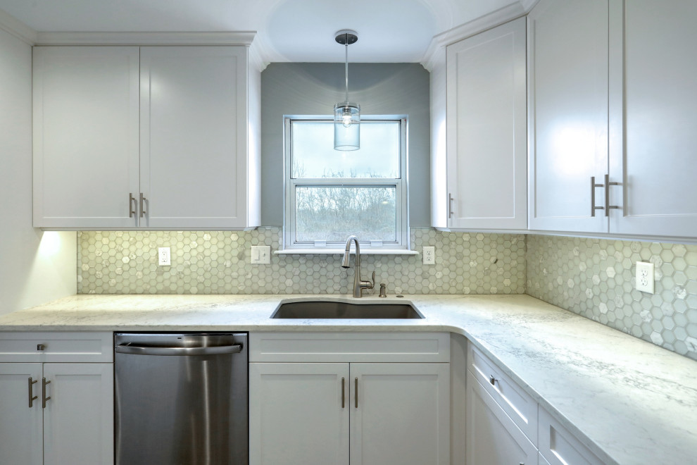 Inspiration for a mid-sized transitional vinyl floor and gray floor eat-in kitchen remodel with an undermount sink, shaker cabinets, white cabinets, quartz countertops, gray backsplash, glass tile backsplash, stainless steel appliances, no island and white countertops