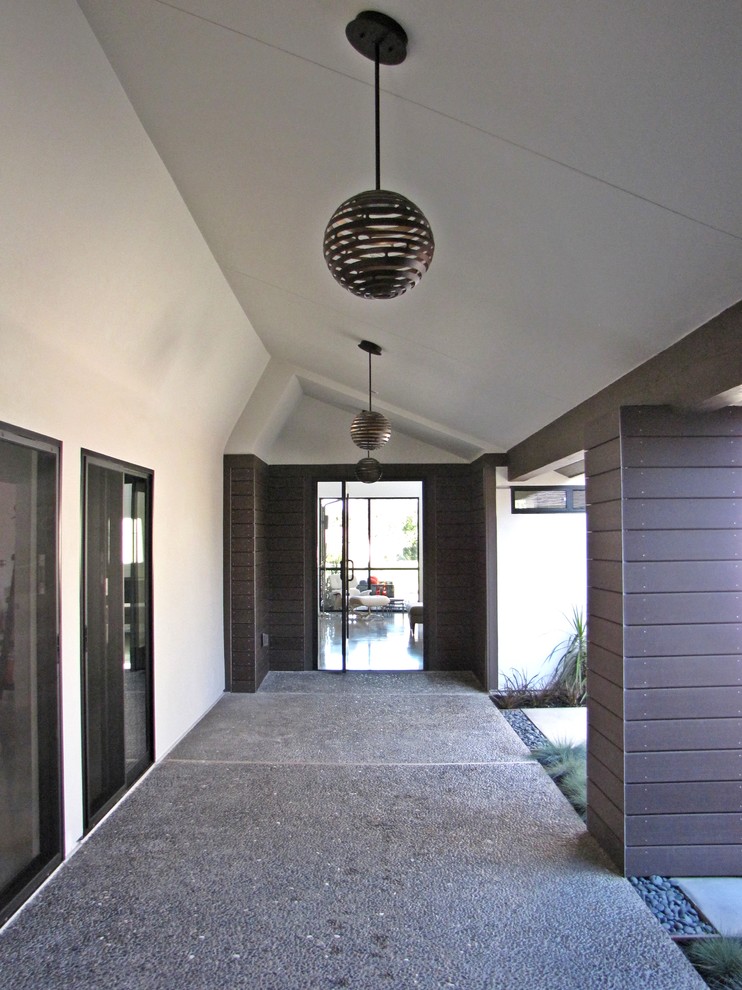 Photo of a midcentury entryway in Orange County with a single front door and a glass front door.