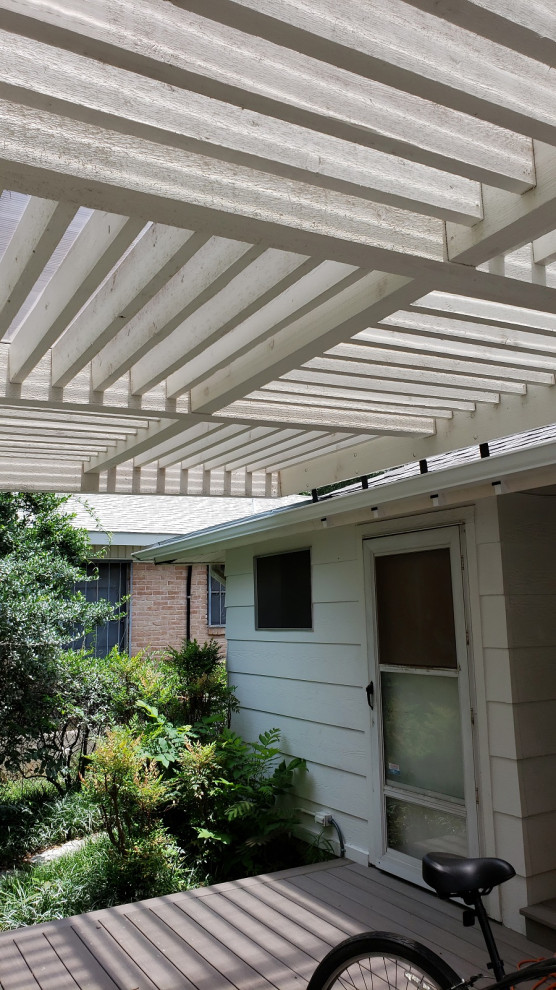 This is an example of a large traditional backyard deck in Austin with a pergola.