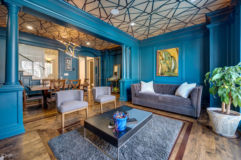 Пример оригинального дизайна: большая открытая гостиная комната в современном стиле с с книжными шкафами и полками, синими стенами, паркетным полом среднего тона, стандартным камином, фасадом камина из плитки и потолком с обоями