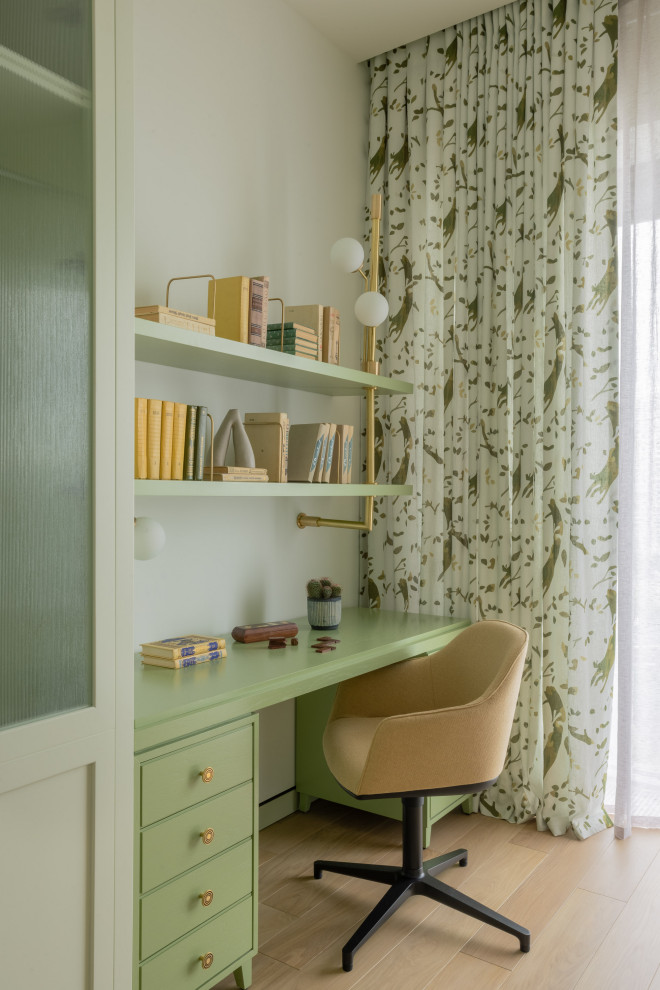 This is an example of a contemporary kids' room in London with green walls.