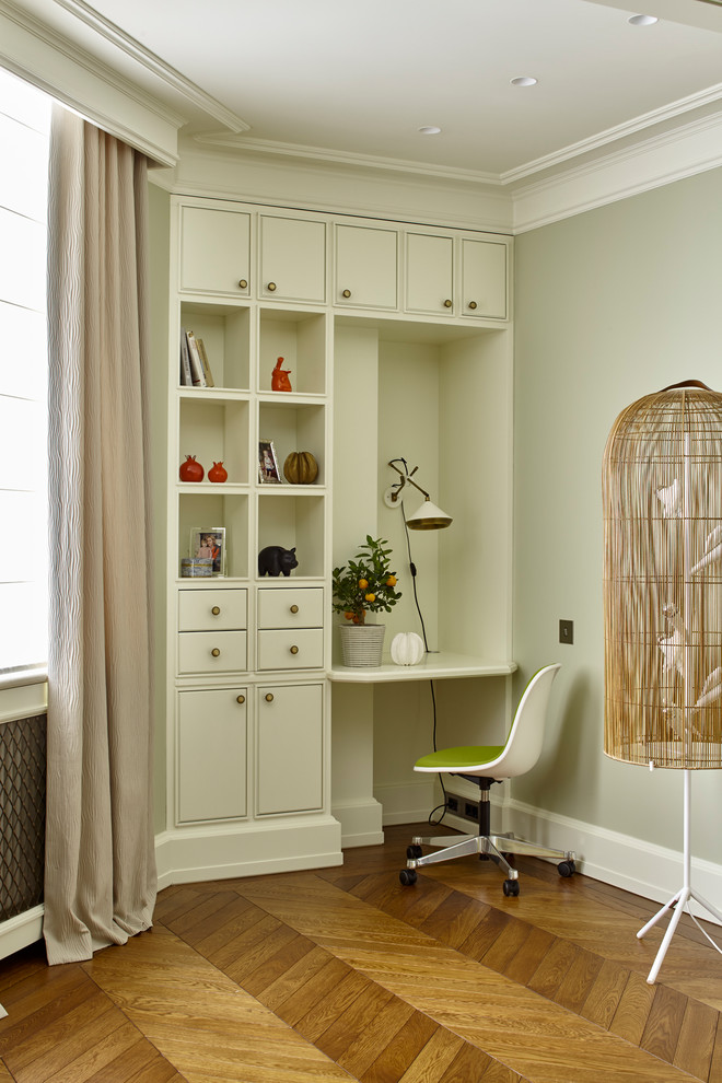 Photo of a transitional study room in Moscow with medium hardwood floors, a built-in desk, brown floor and grey walls.