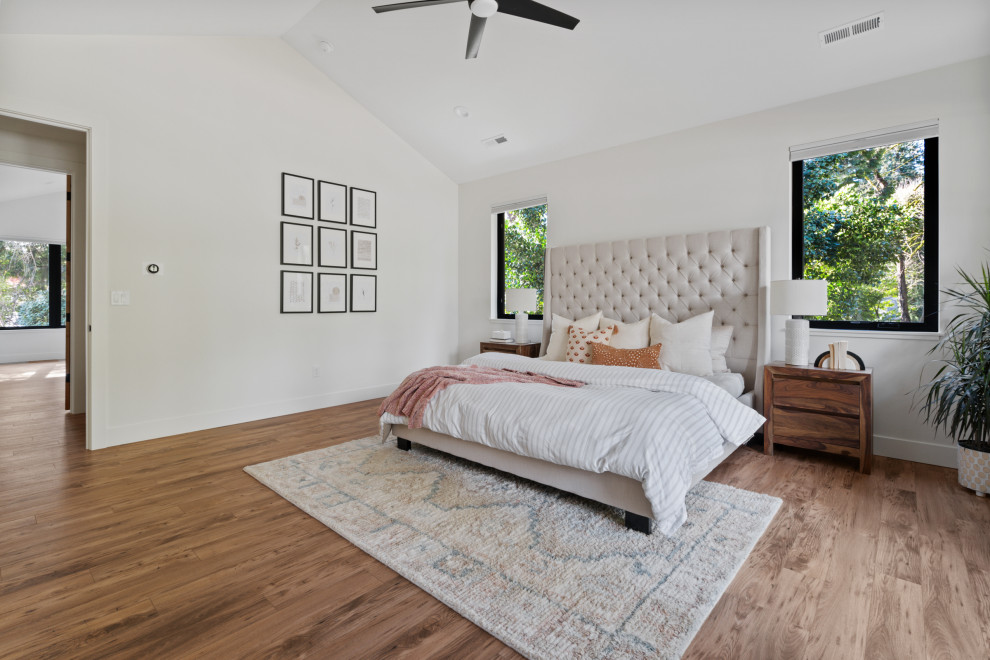 Mittelgroßes Country Hauptschlafzimmer mit weißer Wandfarbe, Laminat, braunem Boden und Holzwänden in Portland