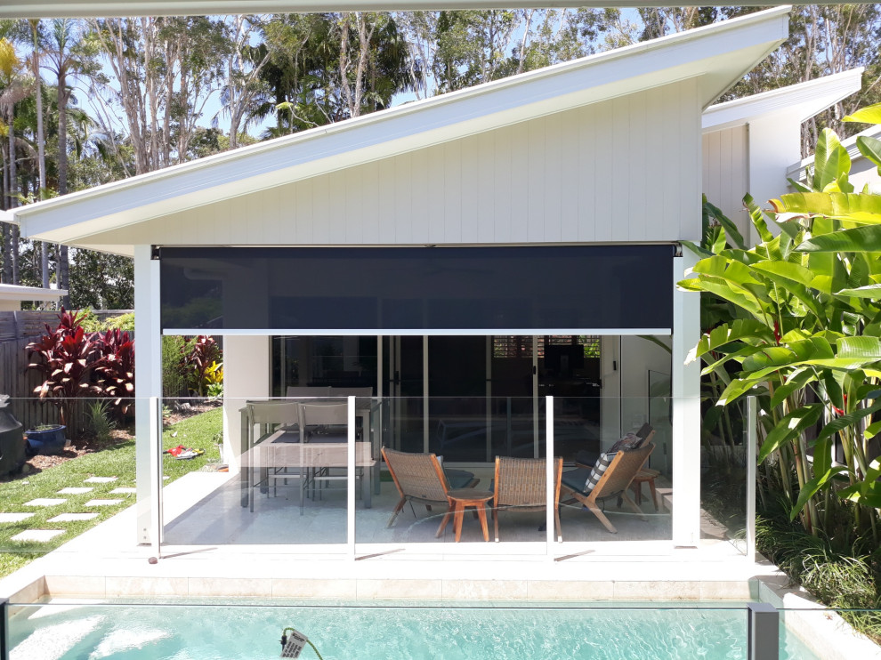 Immagine di un patio o portico minimal di medie dimensioni e dietro casa con un parasole